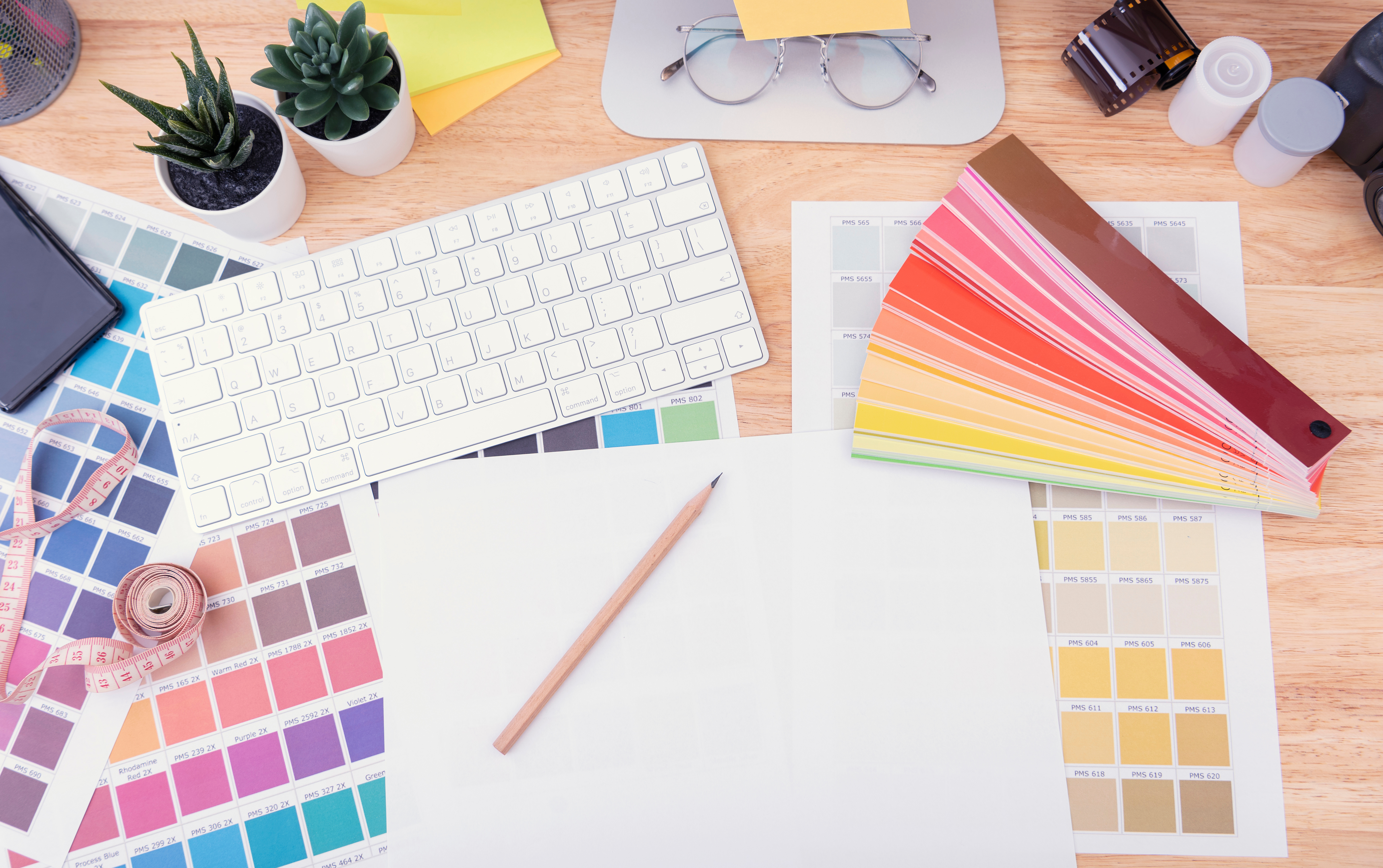 Graphic design workspace with business documents and creative materials